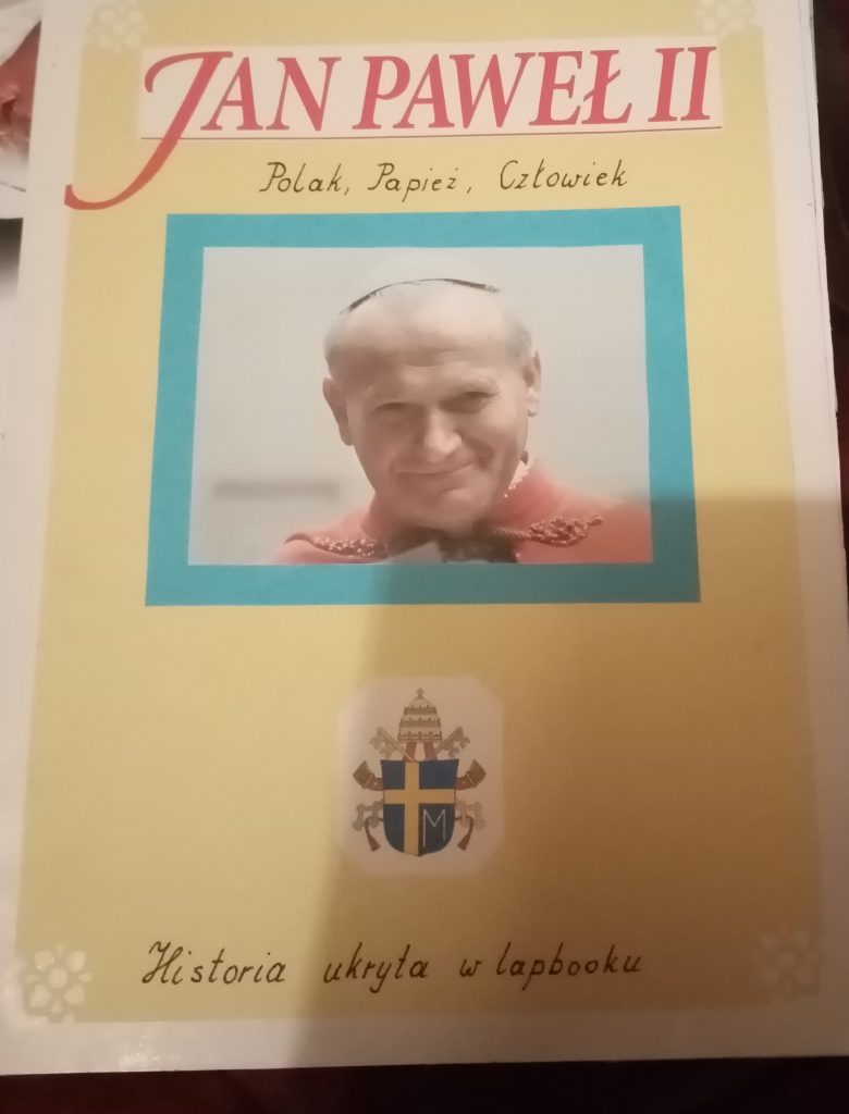 Strona tytułowa lapbooka w kolorze żółtym. Na środku zdjęcie Jana Pawła II.
